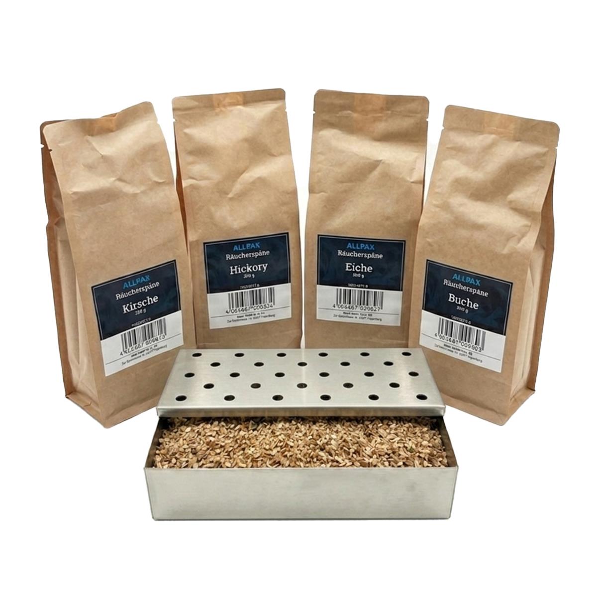 ALLPAX Räucherbox Smokerbox befüllt mit Räucherspänen, im Hintergrund Räucherspänepackungen Buche, Eiche, Kirsche und Hickory