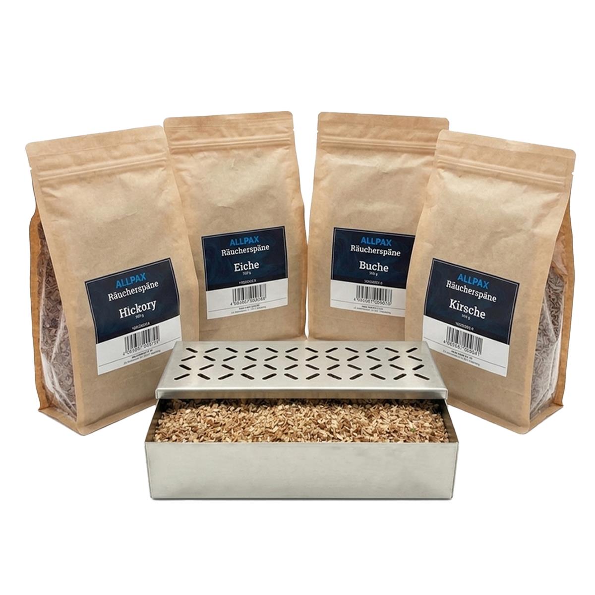 ALLPAX Räucherbox Smokerbox befüllt mit Räucherspänen, im Hintergrund Räucherspänepackungen Buche, Eiche, Kirsche und Hickory